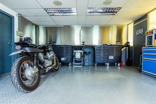 Motocicletă așezată în garaj, pe un stativ, pregătită pentru iernare
